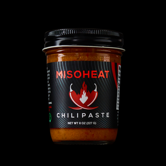 MisoHeat Chili Paste 8oz jar front view, with the logo of hot peppers and flames and a black background