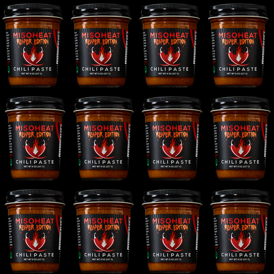 Twelve (12) jars of MisoHeat Chili Paste Reaper Edition, stacked on top of each other, front view.